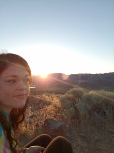 sarah verdugo in nature facing sideways with sun in background