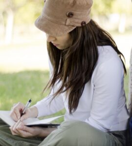 an empowerment center woman writing in her addiction treatment journal